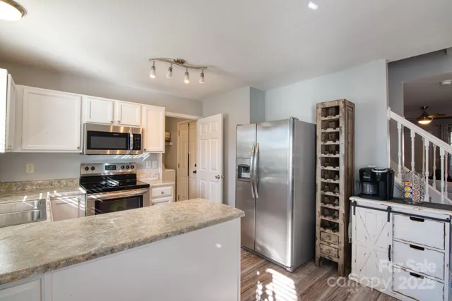 a kitchen with granite countertop a refrigerator and a sink