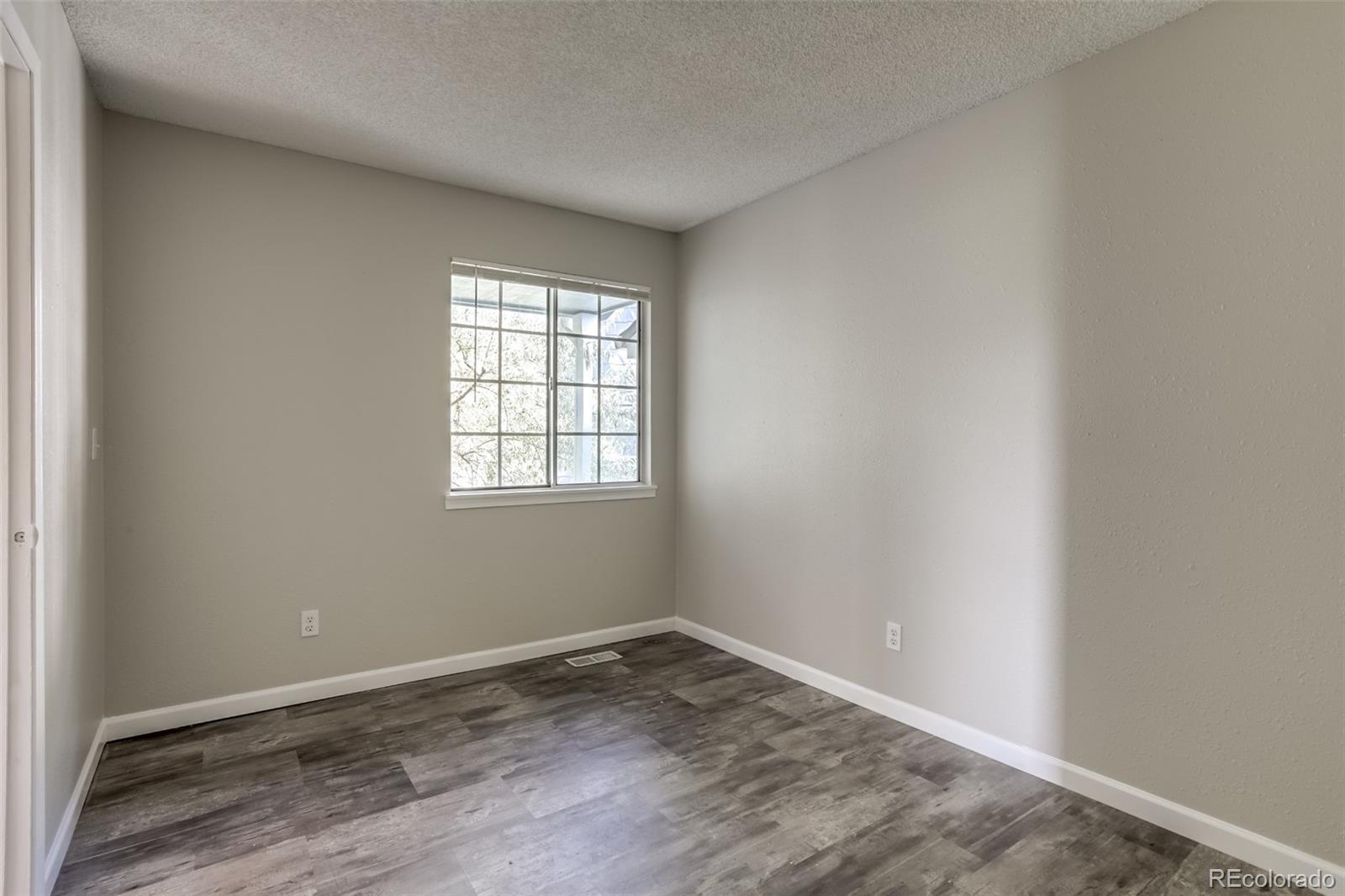 514 Longfellow Lane Highlands Ranch, CO 80126 - Photo 11 of 43 an empty room with wooden floor and windows