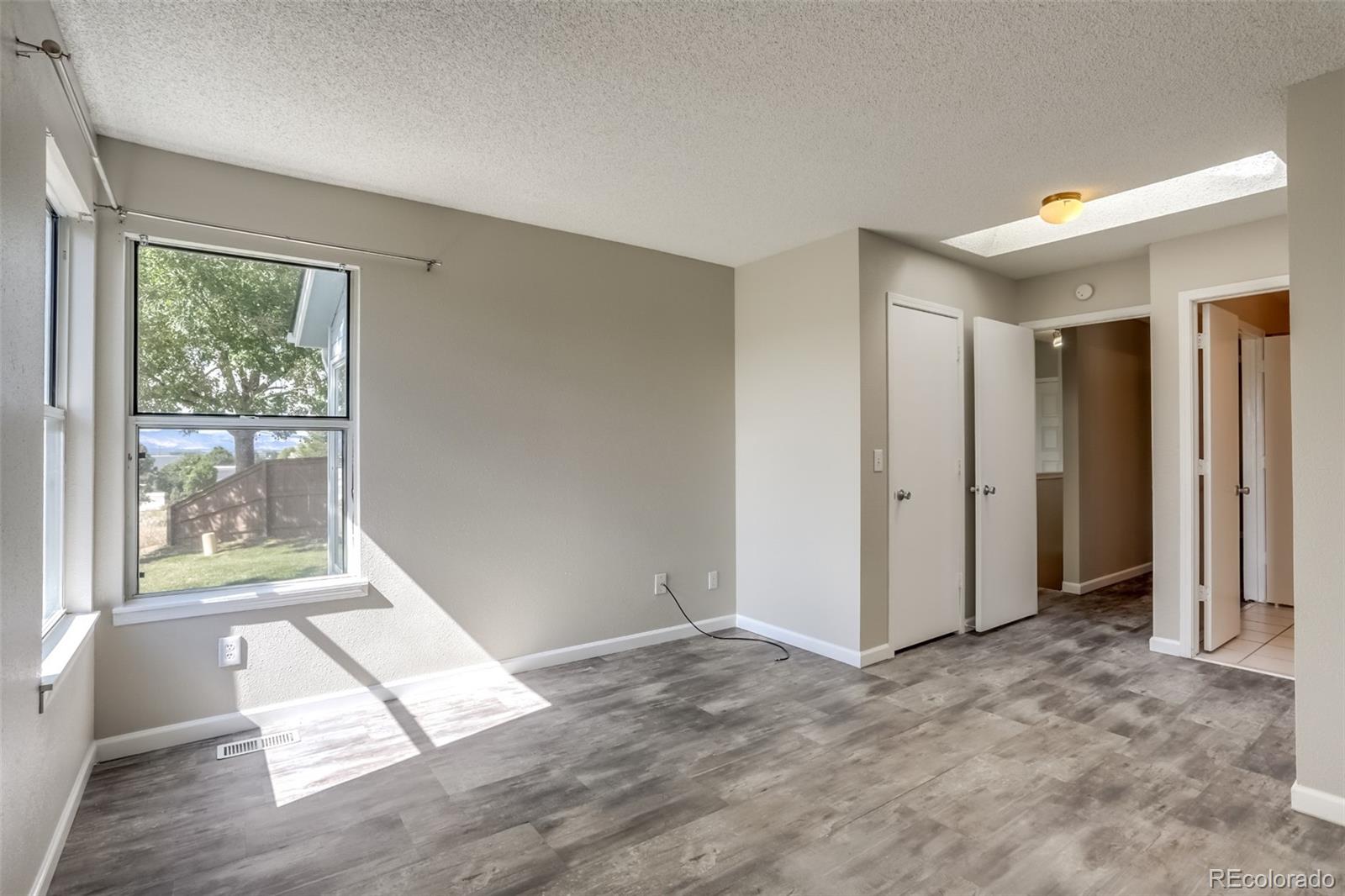 514 Longfellow Lane Highlands Ranch, CO 80126 - Photo 12 of 43 an empty room with wooden floor and windows