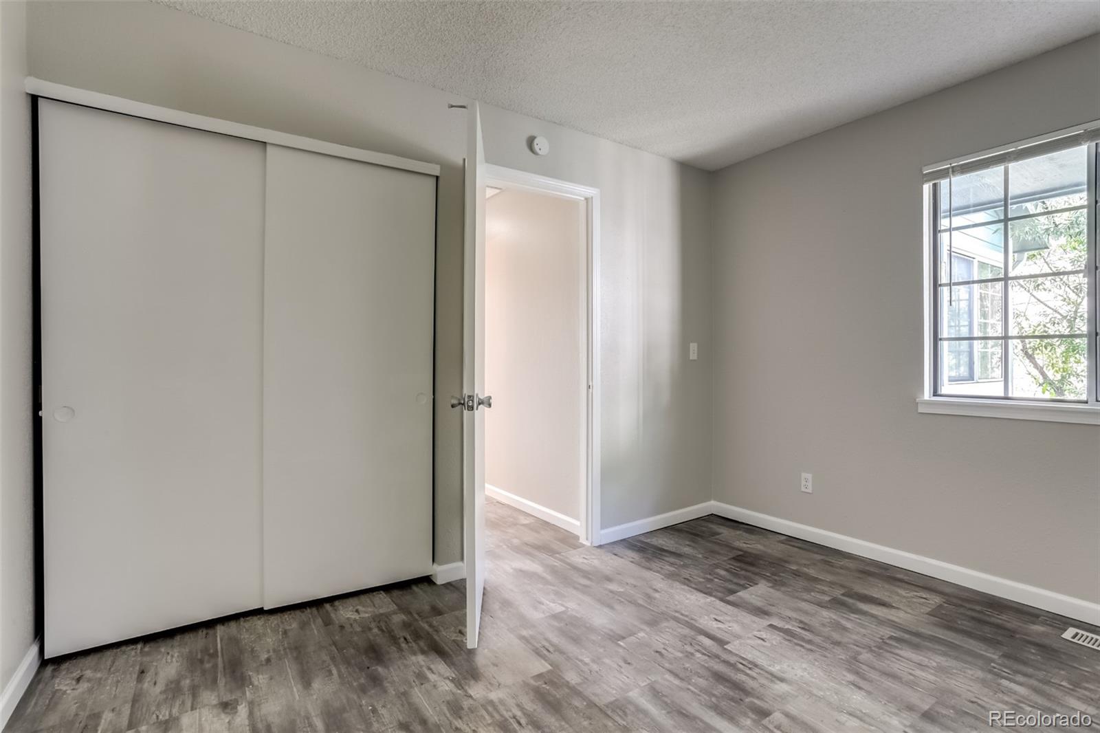 514 Longfellow Lane Highlands Ranch, CO 80126 - Photo 21 of 43 a view of an empty room with wooden floor and a window