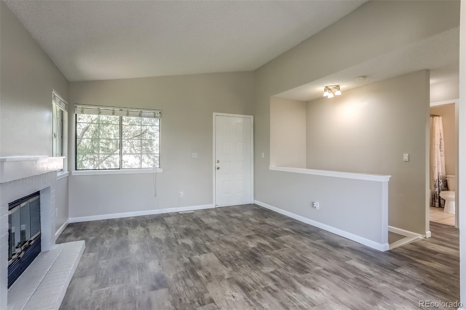 514 Longfellow Lane Highlands Ranch, CO 80126 - Photo 4 of 43 an empty room with windows and fireplace