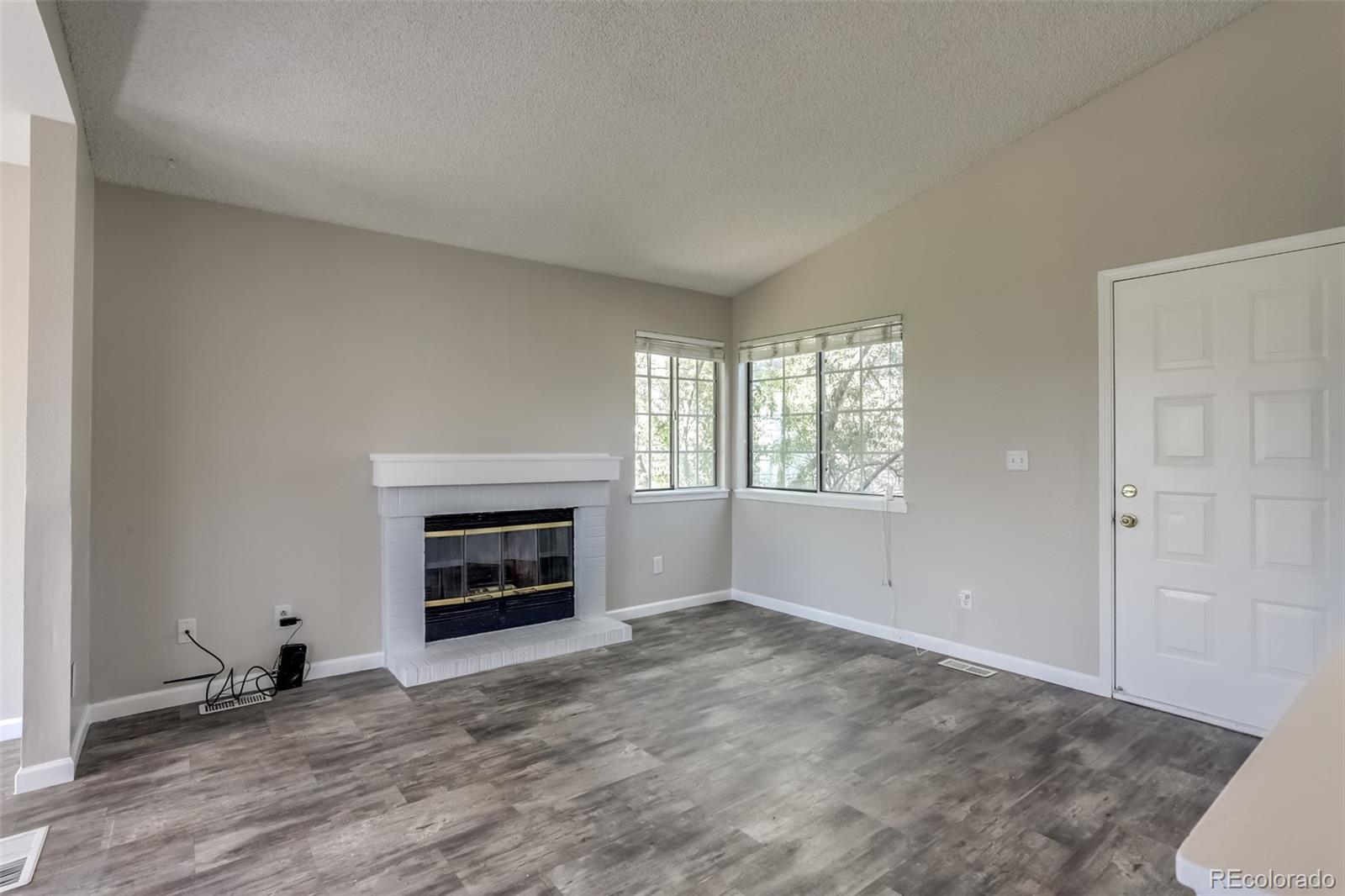 514 Longfellow Lane Highlands Ranch, CO 80126 - Photo 5 of 43 an empty room with windows and fireplace