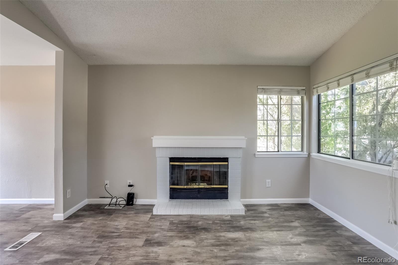 514 Longfellow Lane Highlands Ranch, CO 80126 - Photo 6 of 43 an empty room with windows and fireplace