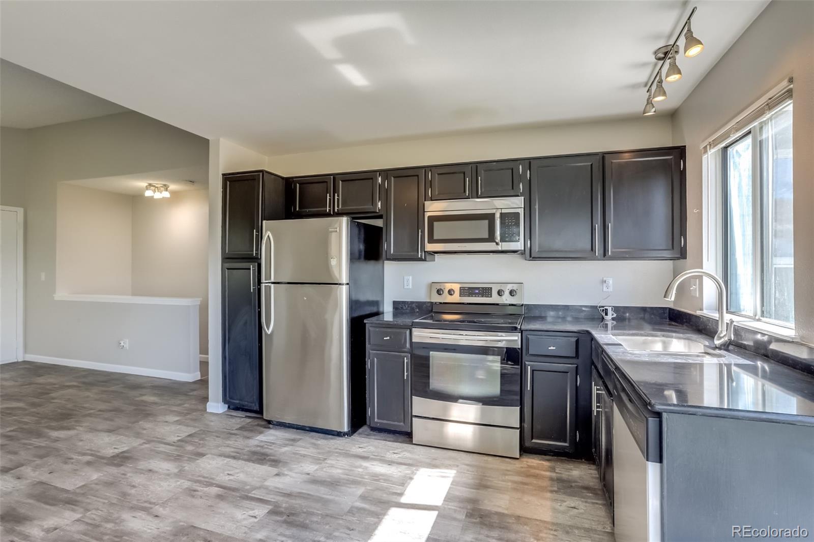 514 Longfellow Lane Highlands Ranch, CO 80126 - Photo 9 of 43 a kitchen with stainless steel appliances granite countertop a refrigerator stove and sink