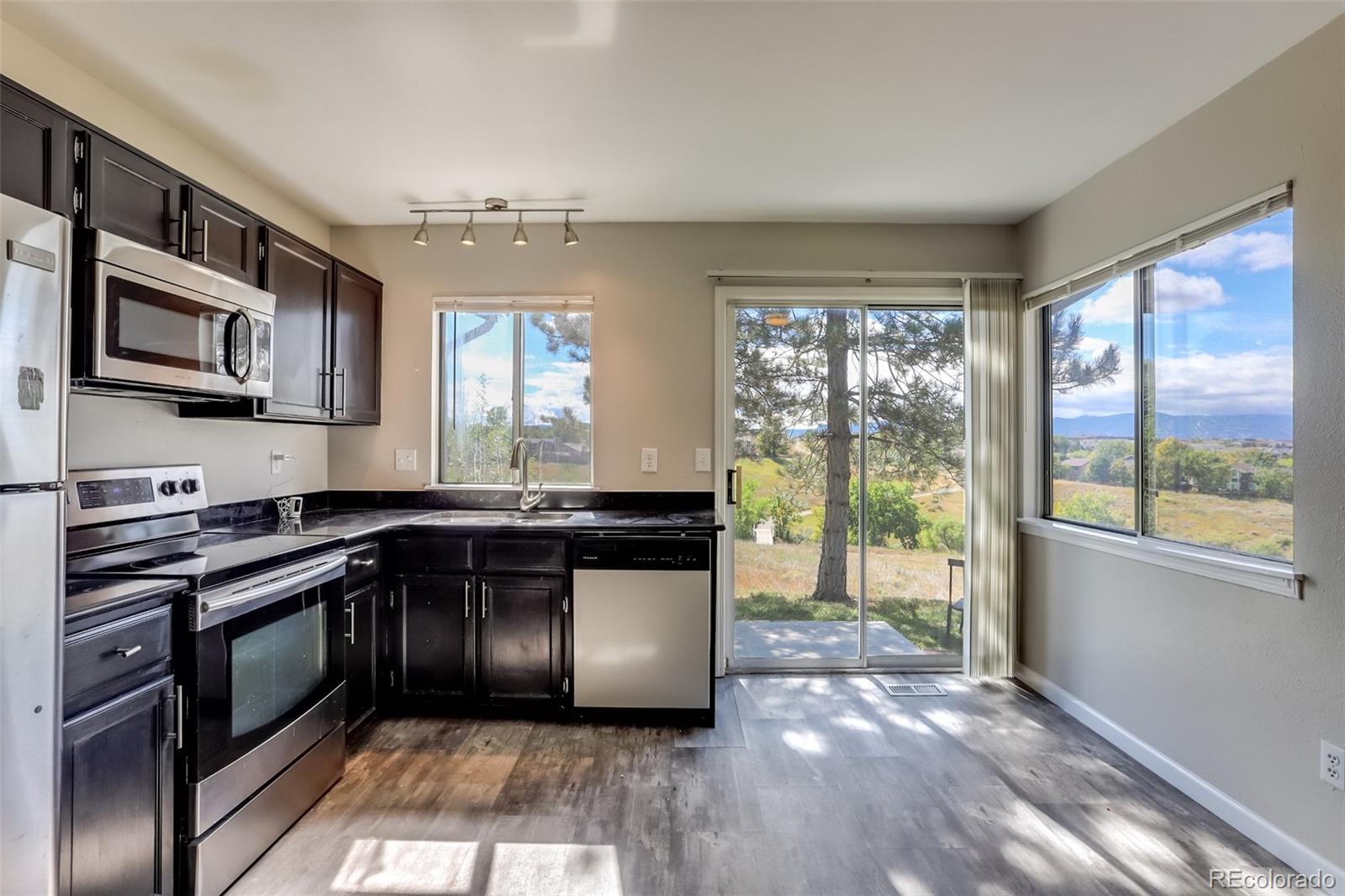 514 Longfellow Lane Highlands Ranch, CO 80126 - Photo 10 of 43 a kitchen with stainless steel appliances granite countertop a stove a sink and a microwave