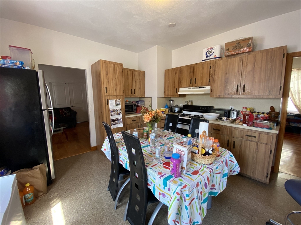 a bedroom with furniture a flat screen tv and a refrigerator