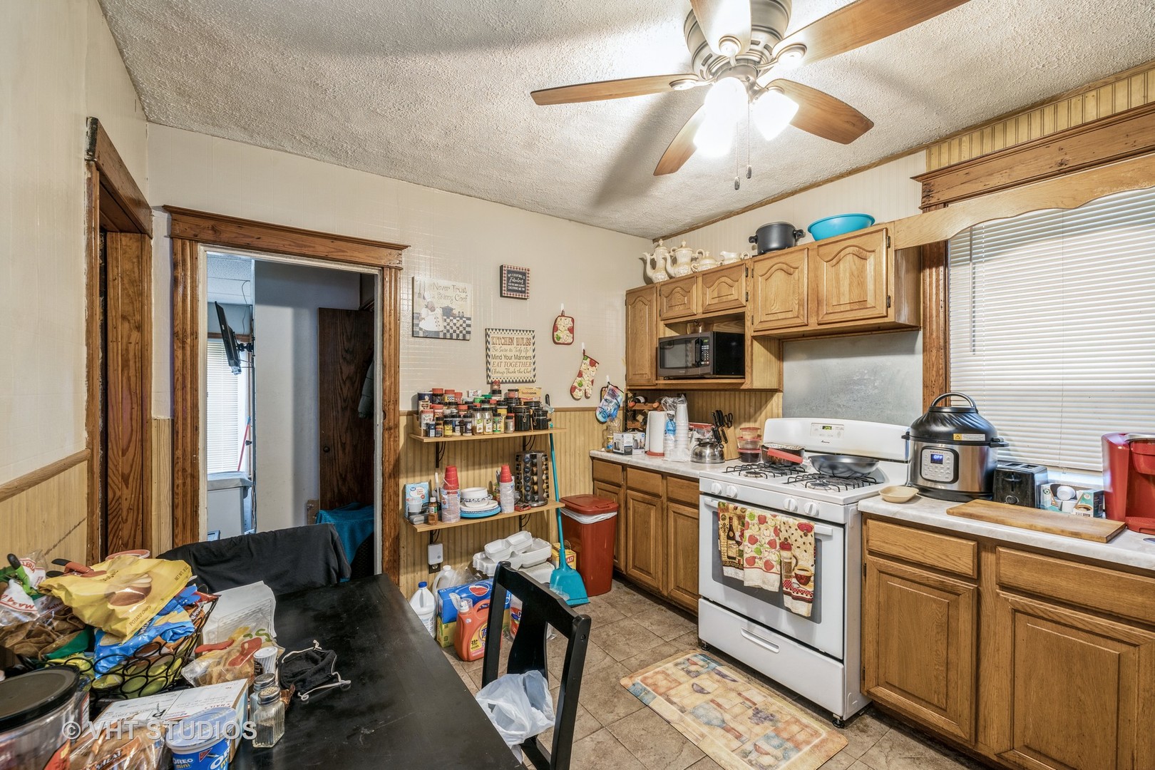 4033 West Cermak Road Chicago, IL 60623 - Photo 6 of 17 a kitchen with lots of clutter and appliances