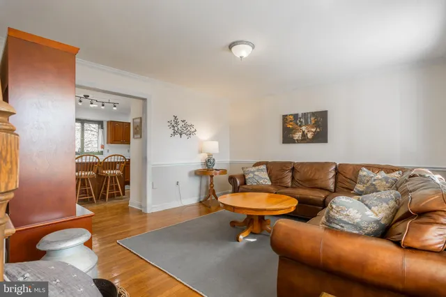 a kitchen with stainless steel appliances granite countertop a stove top oven a sink a refrigerator with a dining table and chairs with wooden floor