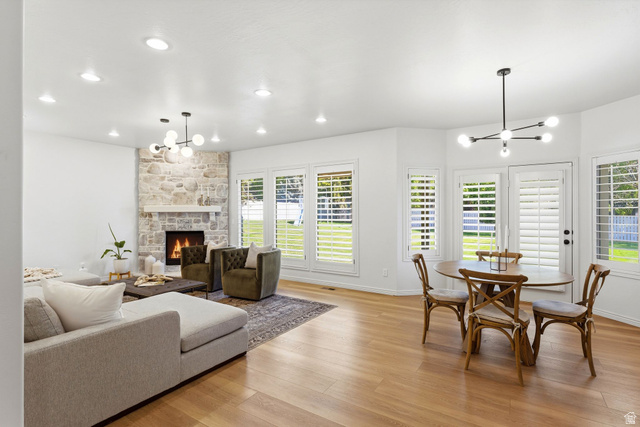 1712 Somerset Ridge Drive Draper, UT 84020 - Photo 24 of 76 Bright living area featuring wood-finish flooring, a stone-clad fireplace with a white mantel, and multiple windows with plantation shutters