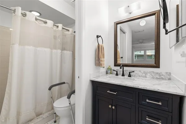 a bathroom with a granite countertop sink toilet and shower