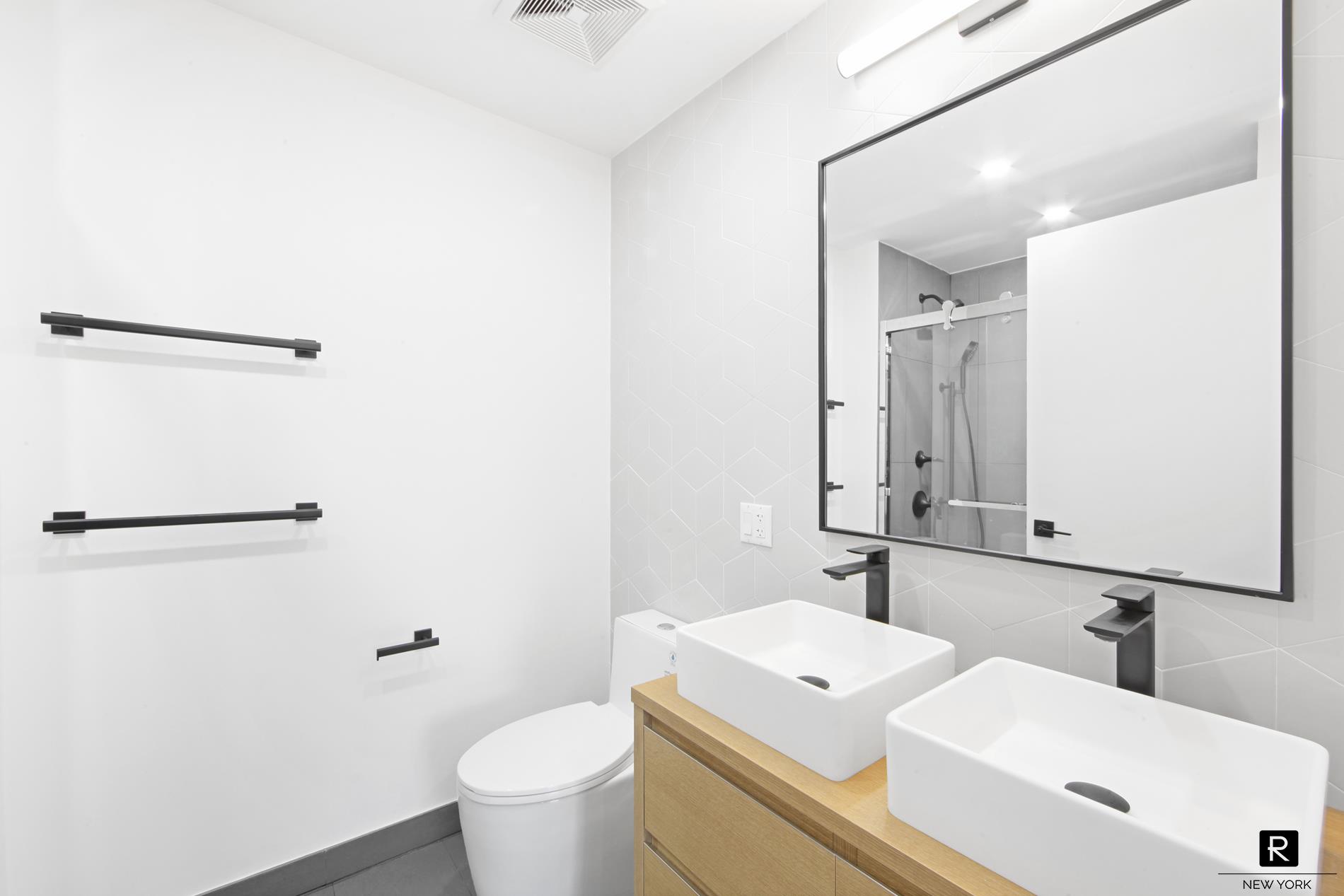 340 Metropolitan Avenue, Unit 5B Brooklyn, NY 11211 - Photo 11 of 12 a bathroom with a toilet a sink and a mirror