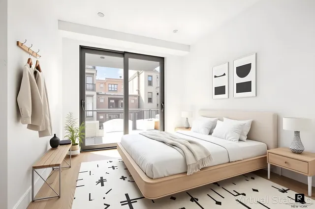 a bedroom with a bed and a large mirror next to a window