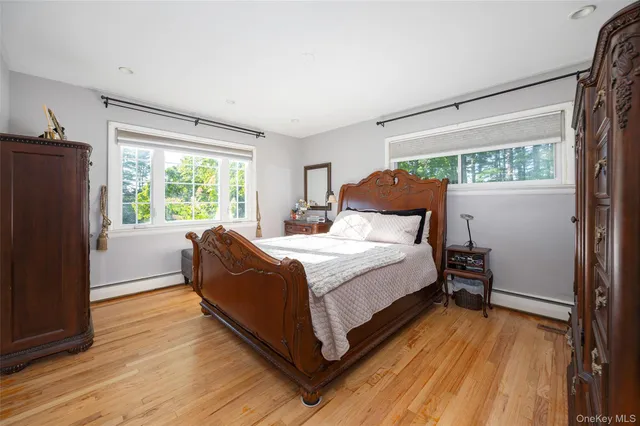 a bedroom with a bed wooden floor and window