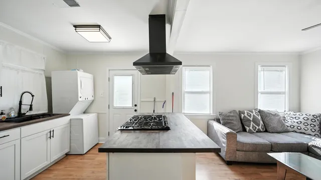 a living room with furniture a table and kitchen view