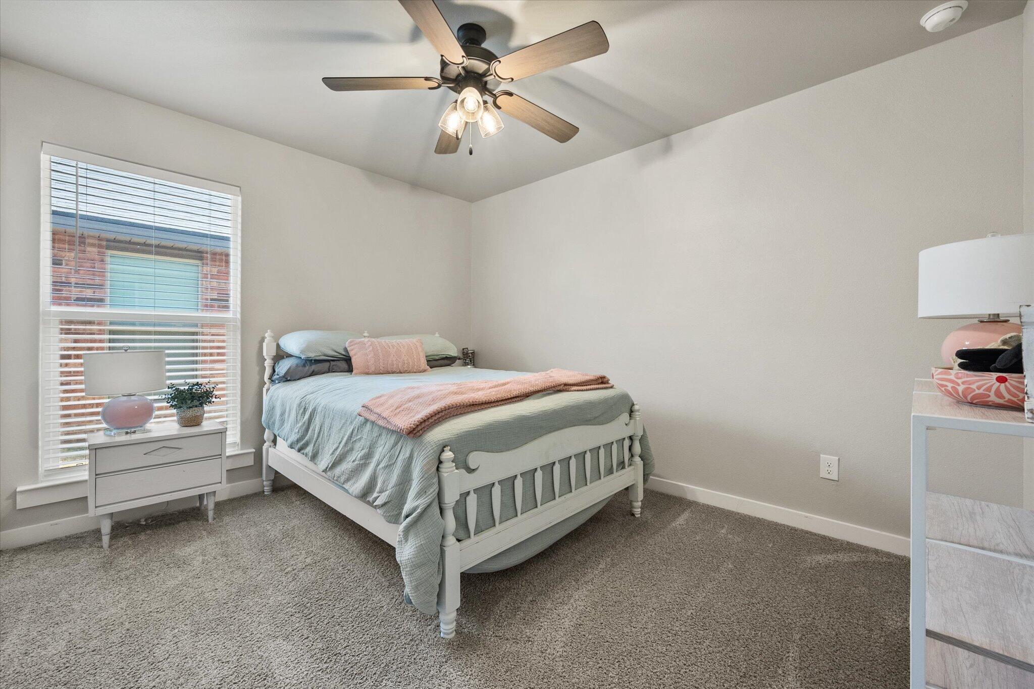 1902 137th Street Lubbock, TX 79423 - Photo 17 of 27 a spacious bedroom with a bed and a chandelier
