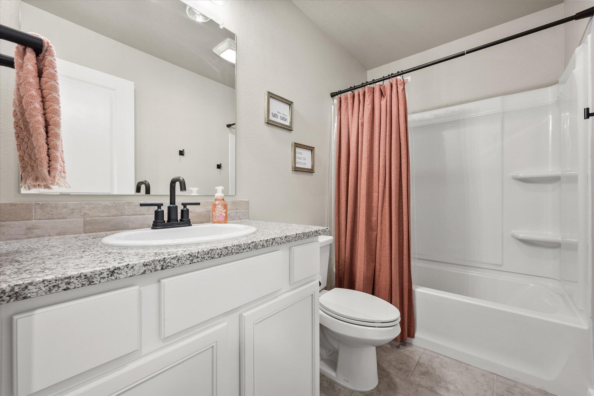 1902 137th Street Lubbock, TX 79423 - Photo 19 of 27 a bathroom with a granite countertop sink toilet and shower