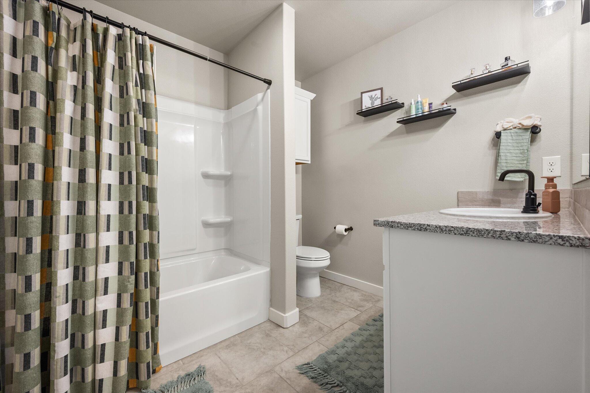 1902 137th Street Lubbock, TX 79423 - Photo 21 of 27 a bathroom with a shower curtain and a sink