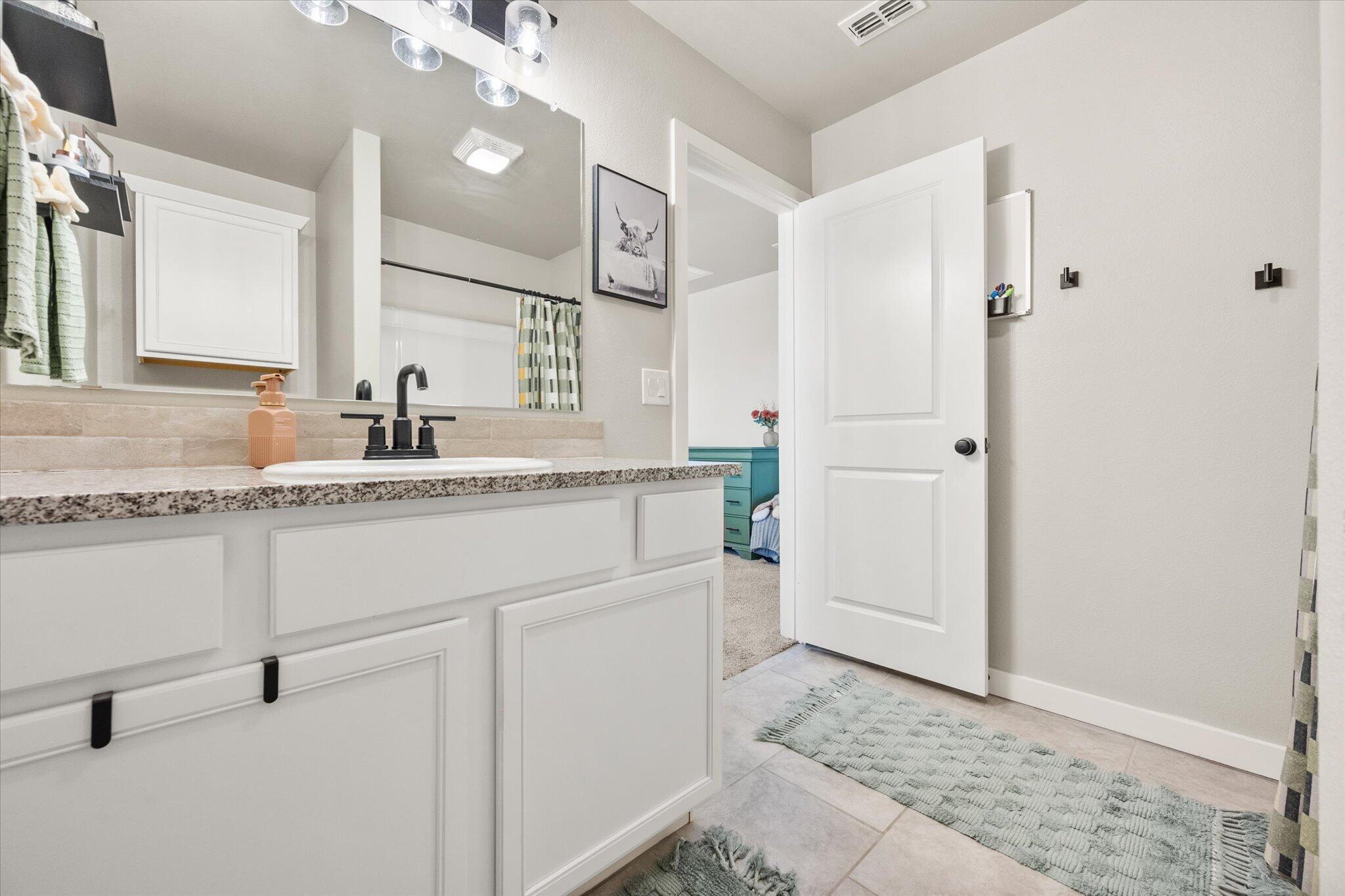 1902 137th Street Lubbock, TX 79423 - Photo 22 of 27 a bathroom with a sink and a mirror