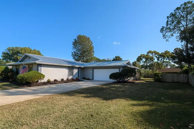 a view of a house with backyard and sitting area
