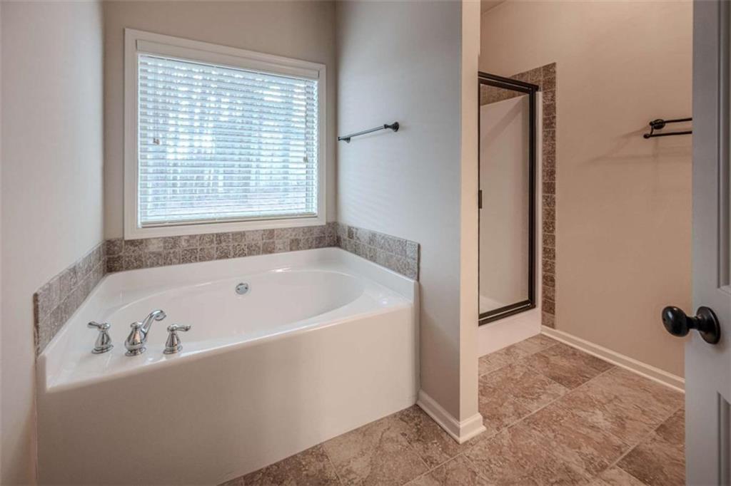 205 Heritage Stroll Athens, GA 30606 - Photo 22 of 30 a bath tub sitting in a bathroom next to a window