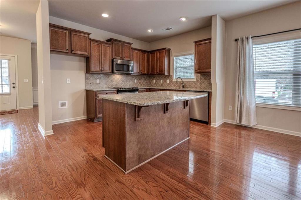 205 Heritage Stroll Athens, GA 30606 - Photo 6 of 30 a kitchen with stainless steel appliances granite countertop a stove a sink dishwasher and a refrigerator with wooden floor
