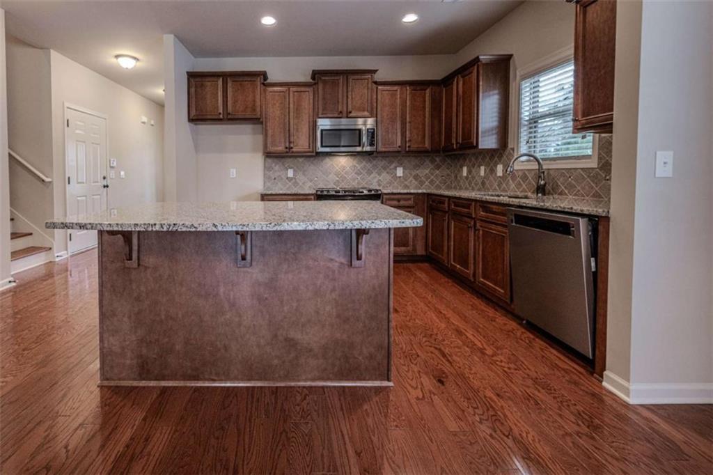 205 Heritage Stroll Athens, GA 30606 - Photo 10 of 30 a kitchen with stainless steel appliances granite countertop a sink stove and cabinets