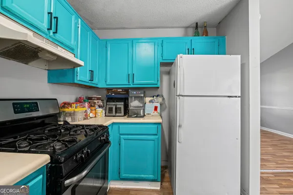 a kitchen with a refrigerator and a stove top oven