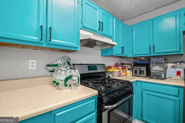 a kitchen with stainless steel appliances granite countertop a stove a refrigerator a sink dishwasher and cabinets with wooden floor