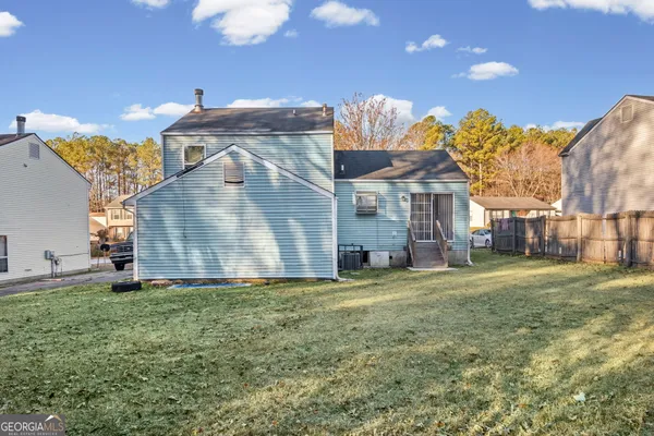 a view of a big house with a big yard and a large tree