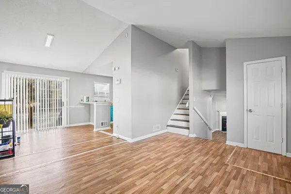 a view of a kitchen with wooden floor and stairs