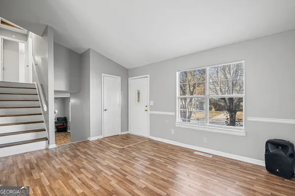 a view of a bedroom with wooden floor and a window