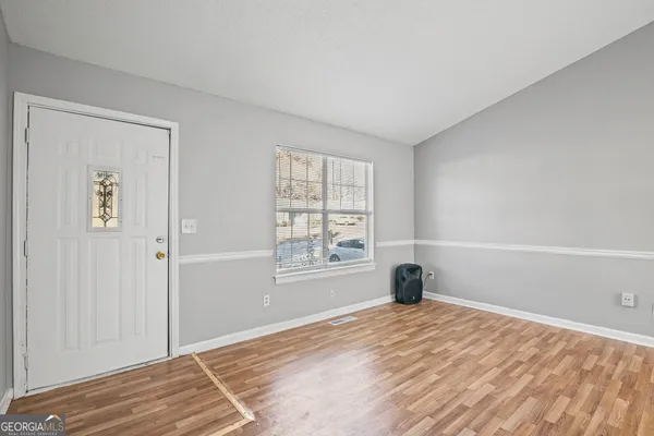 a view of a livingroom with wooden floor and a window