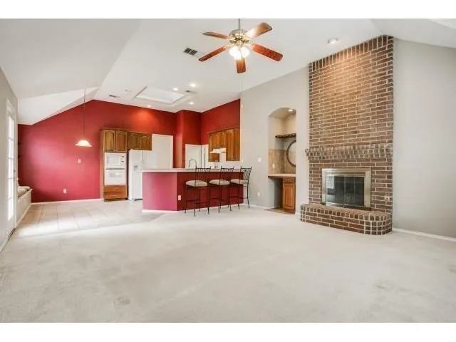 a open kitchen view with fireplace cabinets and a ceiling fan
