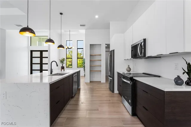 a kitchen with stainless steel appliances granite countertop a sink a stove and a refrigerator