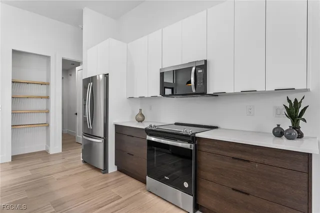 a kitchen with stainless steel appliances white cabinets and a stove