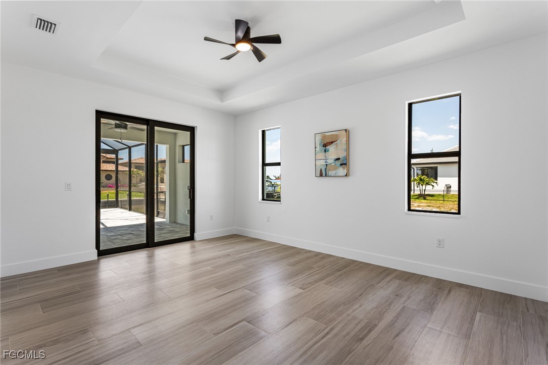 2702 Old Burnt Store Road North Cape Coral, FL 33993 - Photo 23 of 44 a view of an empty room with a window and wooden floor