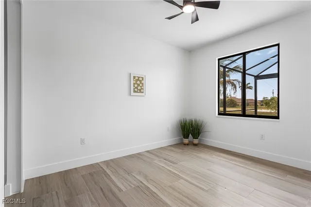 an empty room with a window and wooden floor
