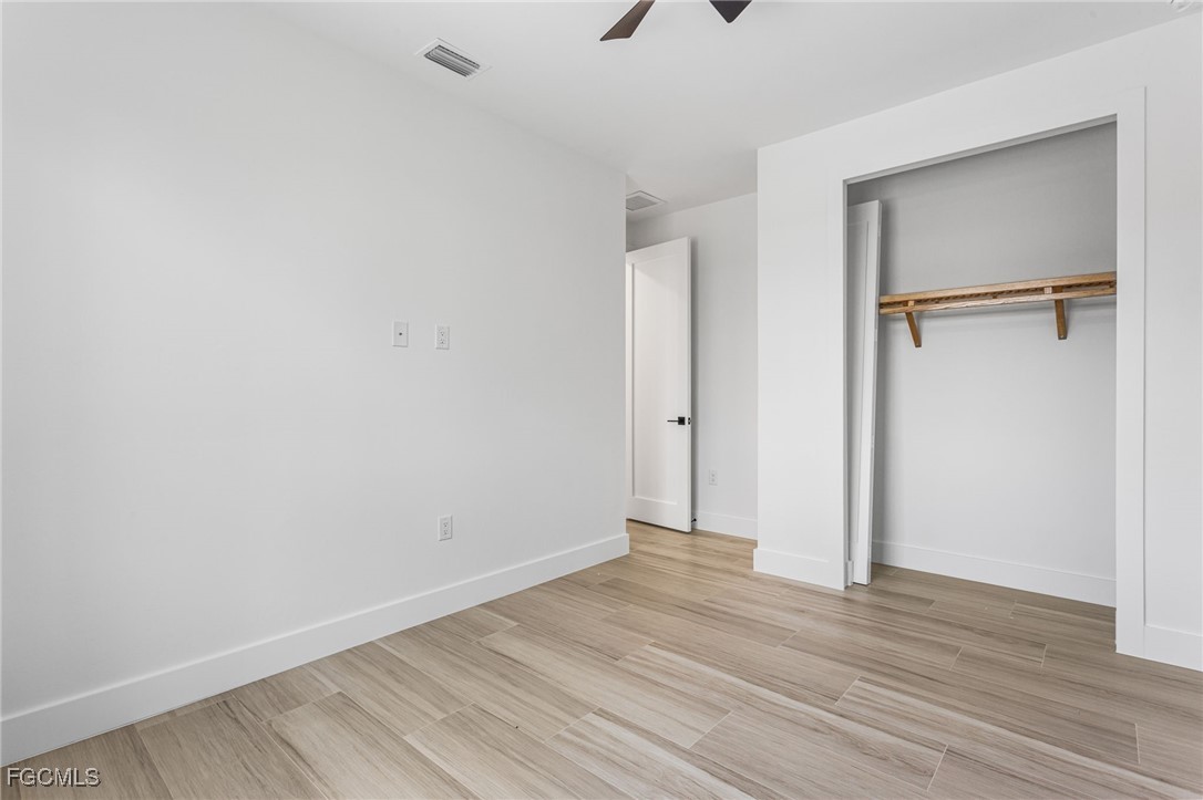 2702 Old Burnt Store Road North Cape Coral, FL 33993 - Photo 32 of 44 a view of an empty room with wooden floor and a window