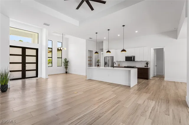 a large kitchen with stainless steel appliances kitchen island a large counter top and a wooden floors
