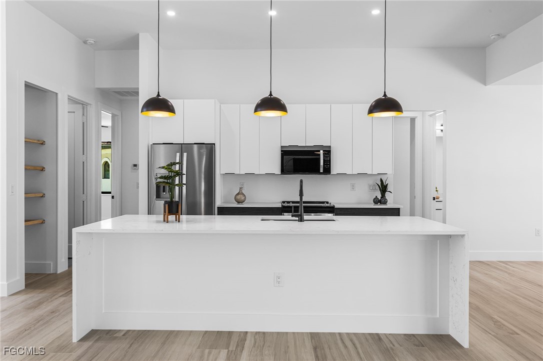 2702 Old Burnt Store Road North Cape Coral, FL 33993 - Photo 9 of 44 a kitchen with stainless steel appliances granite countertop a sink a stove and a refrigerator