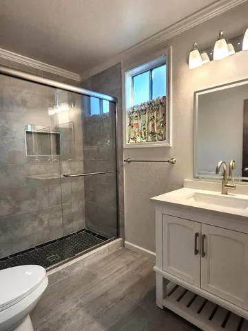 a bathroom with a sink a toilet and shower