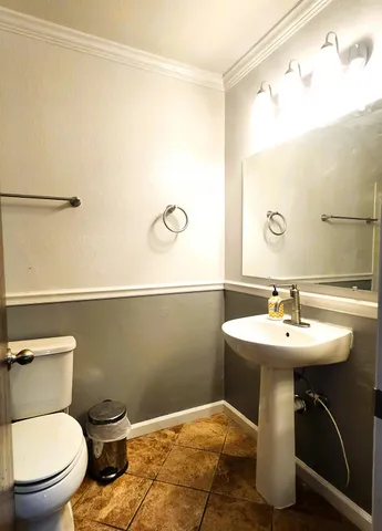 a bathroom with a sink mirror and toilet