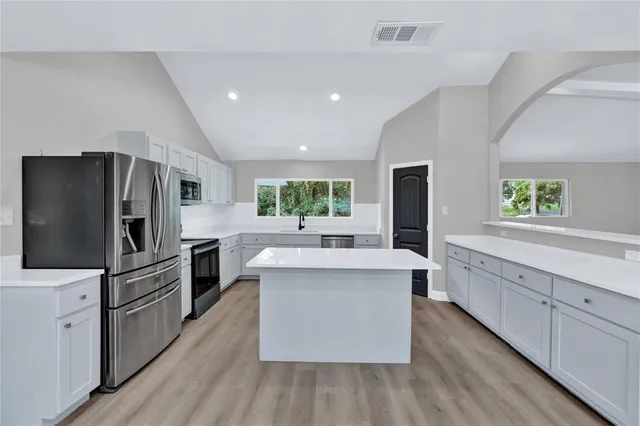 a kitchen with stainless steel appliances a sink and a refrigerator