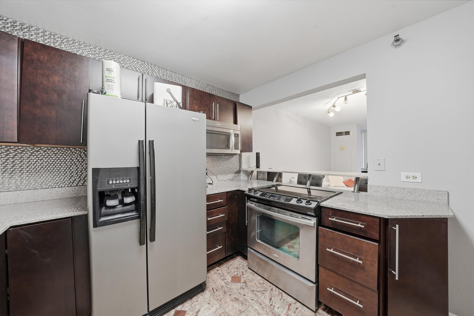 200 North Dearborn Street, Unit 906 Chicago, IL 60601 - Photo 5 of 15 a kitchen with stainless steel appliances granite countertop a refrigerator stove and sink