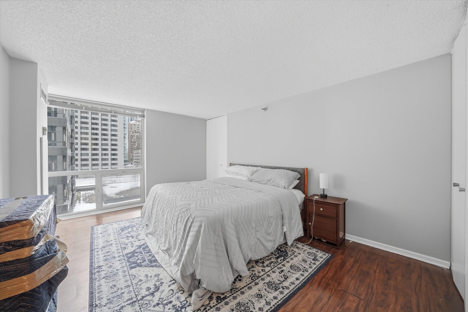 200 North Dearborn Street, Unit 906 Chicago, IL 60601 - Photo 7 of 15 a bedroom with a bed and wooden floor
