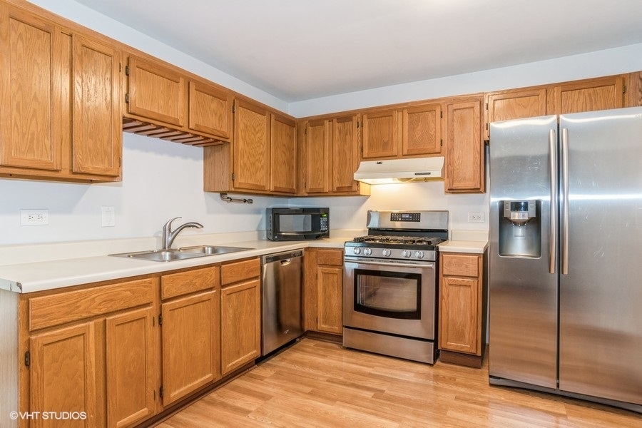 309 North Oltendorf Road Streamwood, IL 60107 - Photo 4 of 11 a kitchen with a sink stainless steel appliances and cabinets