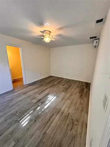a view of room with wooden floor and fan