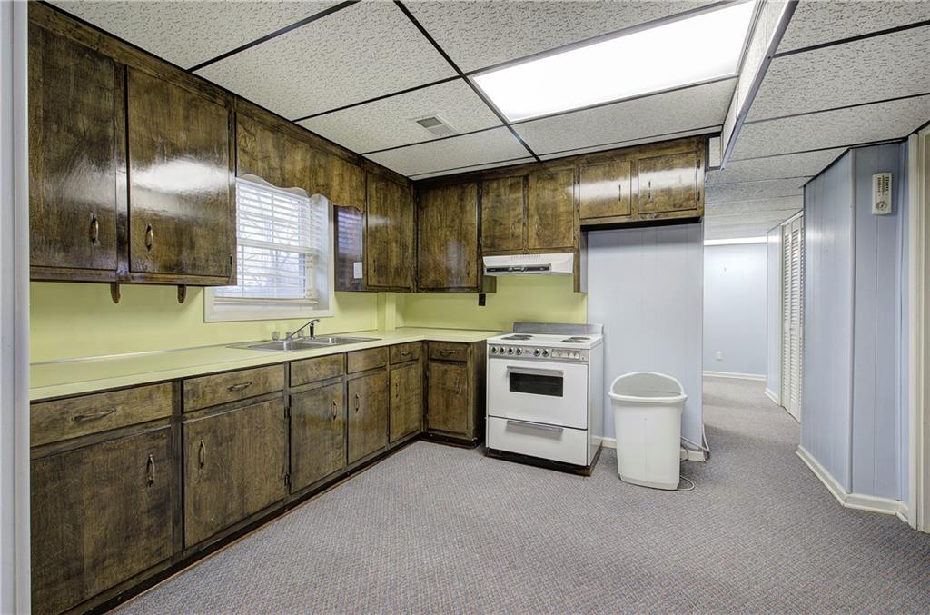 408 Mac Johnson Road Northwest Cartersville, GA 30121 - Photo 43 of 62 a large white kitchen with a sink and dishwasher a stove top oven with wooden floor