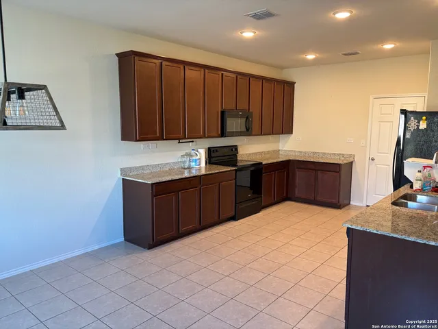 a kitchen with stainless steel appliances granite countertop a stove a sink and a microwave