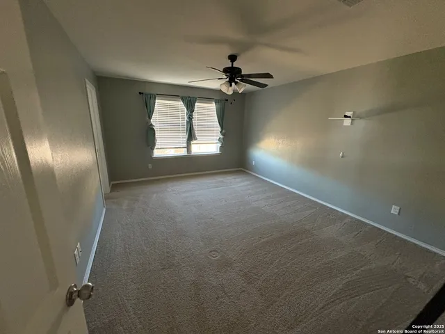 an empty room with windows and fan